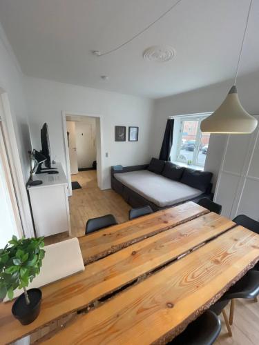 a living room with a table and a couch at Central apartment with parking and Netflix in Aarhus