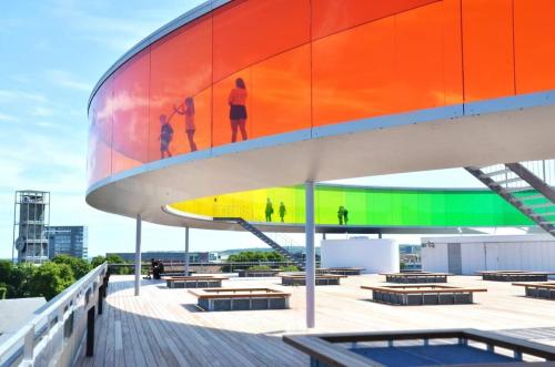 a colorful building with benches and people painted on it at Central apartment with parking and Netflix in Aarhus
