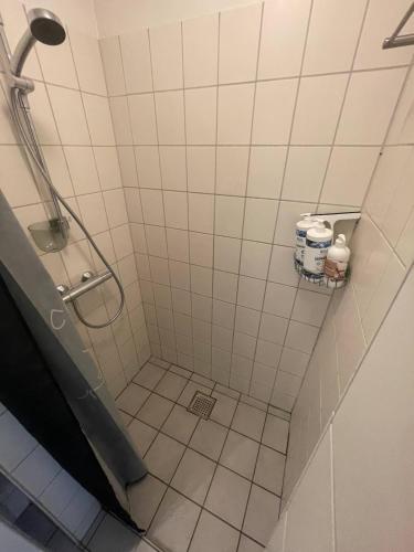 a bathroom with a shower with white tiles at Central apartment with parking and Netflix in Aarhus