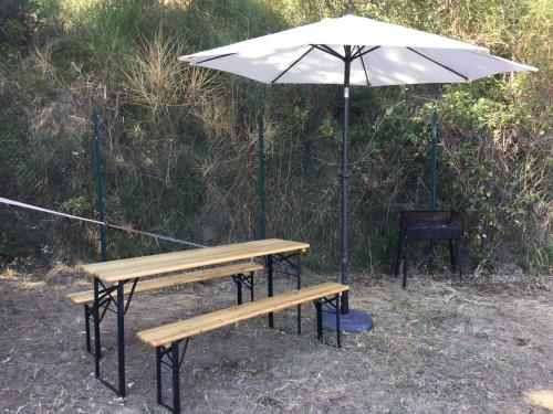 a picnic table with an umbrella and a bench at B&B dell'Aviatore in San Liberato