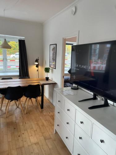 a living room with a desk with a flat screen tv at Central apartment with parking and Netflix in Aarhus