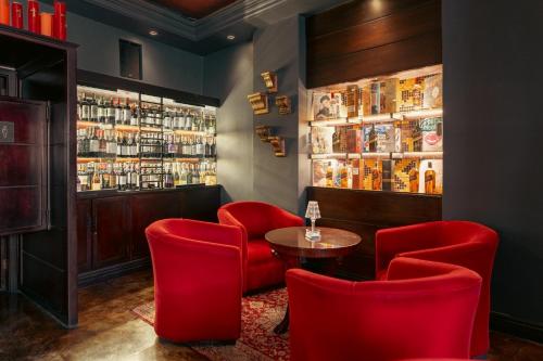 a bar with red chairs and a table and shelves at Hotel Boutique Santa Lucia in Cuenca