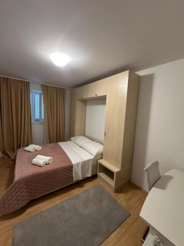 a bedroom with a bed with two towels on it at Apartment Oblak in Vrsi
