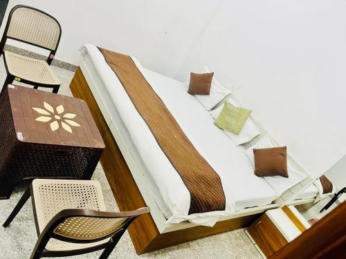 a bed sitting on top of a table and chairs at RADHIKA INn in Khātu
