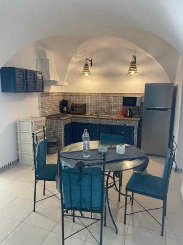 a kitchen with a table and chairs in a room at BUNGALOW El HOUDA in Hammamet
