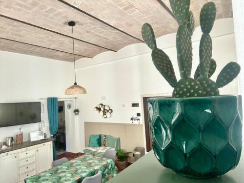 a green vase sitting on a table with a cactus at VerdeNera in Terni