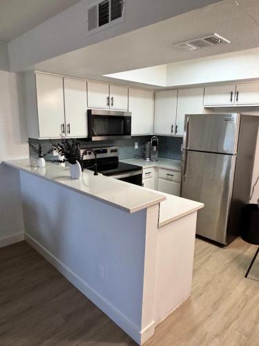 a kitchen with white cabinets and stainless steel appliances at Mesa 1bedroom king size near Tempe & parks in Mesa
