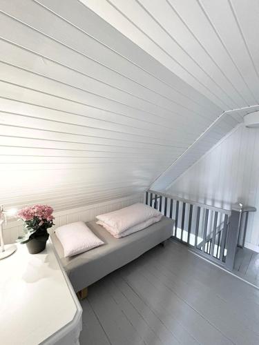a bench with two pillows and a vase of flowers at Charming Seaside Home with Fjord Views in Asker
