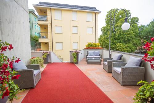 a patio with a red carpet and chairs and a building at Hotel Ferrari in Salsomaggiore Terme