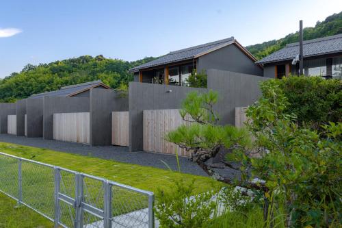 a house with a fence in front of a yard at Villa NIGIN in Miyazu