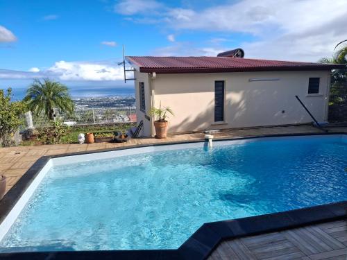 a swimming pool in front of a house at La case des oiseaux in La Possession