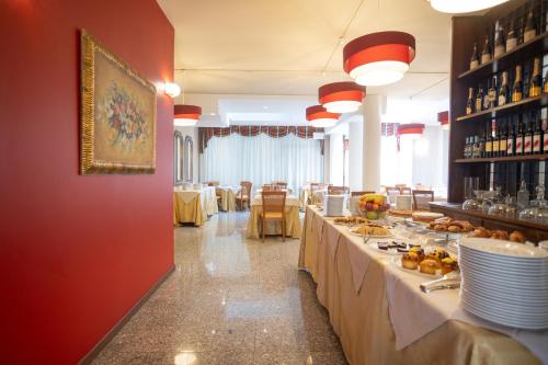 a restaurant with a buffet line with tables of food at Hotel Ferrari in Salsomaggiore Terme