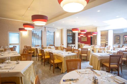 a dining room with tables and chairs and lights at Hotel Ferrari in Salsomaggiore Terme