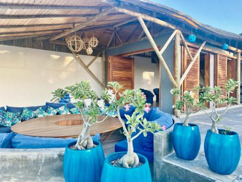 a group of blue pots with trees in front of a table at Villa Beleza Prea Beachfront private room in Prea