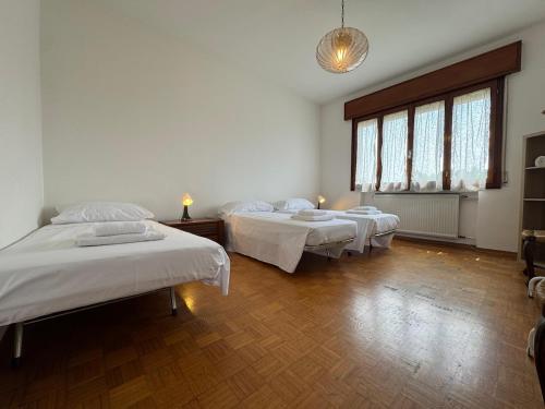 a room with three beds and a large window at Top accommodation for flights and groups in Crespano del Grappa