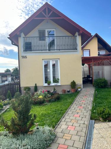a yellow house with a balcony on a yard at Ubytovanie u Vlasty in Štrba