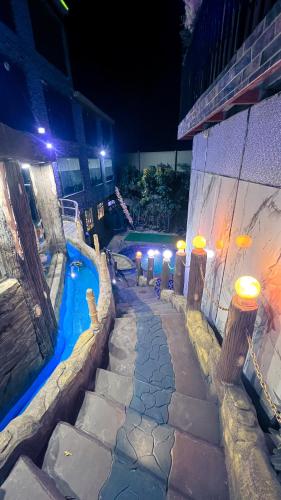 a swimming pool next to a building at night at شاليه واستراحة روزلاند in Ḩişn al Qā‘
