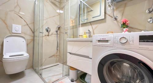a bathroom with a washing machine and a shower at Harmony Apartment 2 in Bar