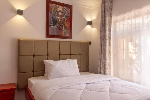a bed in a bedroom with a painting on the wall at Namayani Safari Lodge in Arusha