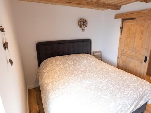 a bedroom with a bed and a wooden door at Ferme PFRIMMER in Breuschwickersheim