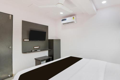 a room with a bed and a tv on a wall at Hotel O New A1 in Ahmedabad