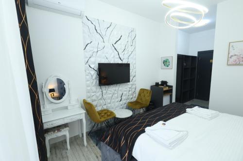 a hotel room with a bed and a tv on a wall at Golden Hill Palace in Novi Pazar