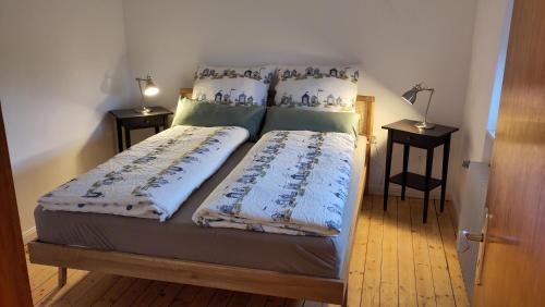a bed in a room with two nightstands and two tables at Ferienhaus Landblick in Bad Arolsen