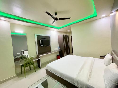 a bedroom with a bed and a ceiling with green lights at SEA VIEW- Family Hotel New T B- Resort inn, puri - near sea beach and Jagannath temple in Puri