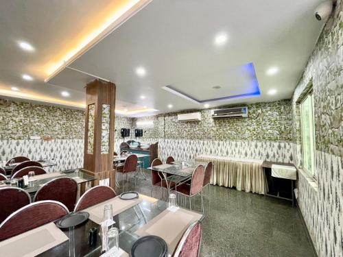 a restaurant with tables and chairs in a room at SEA VIEW- Family Hotel New T B- Resort inn, puri - near sea beach and Jagannath temple in Puri