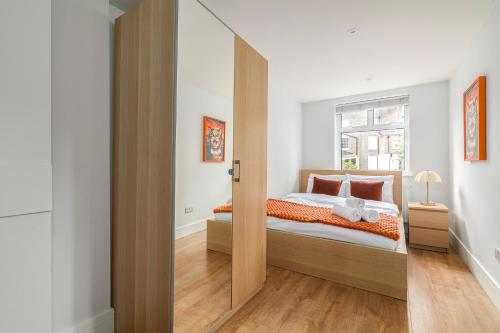 a bedroom with a bed and a sliding glass door at Stylish Camden Town Apartments in London