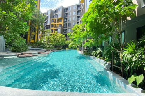 a pool in the middle of a city with buildings at Luxury Resort Style 1 Bedroom Studio near Central in Phuket