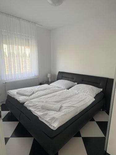 a bed with two towels on it in a bedroom at Apartamenty Na Fali in Kołobrzeg