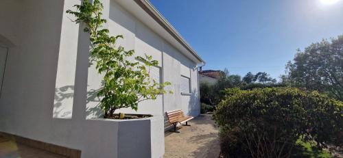 a bench next to a building with a tree at Villa Papa João XXIII in Fátima