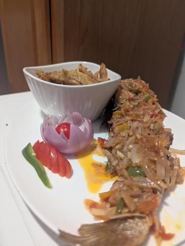 a plate of food on a table with a bowl of food at The Blue Resort in Yaoundé