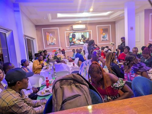 a group of people sitting at tables in a room at The Blue Resort in Yaoundé