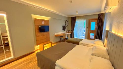 a hotel room with two beds and a television at Istankoy Hotel in Bodrum City