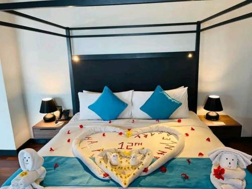 a bedroom with a heart shaped bed with two stuffed animals at Avani Sepang Goldcoast Resort in Tanjong Sepat