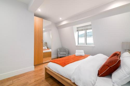 a white bedroom with a bed and a window at Stylish Camden Town Apartments in London
