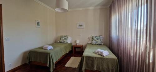 two green beds in a room with a window at Villa Papa João XXIII in Fátima