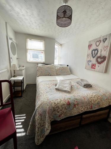 a bedroom with a bed with a bedspread on it at Relax Inn Guest House in Brighton & Hove