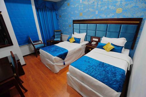 a hotel room with two beds and blue walls at 33 Soksoom Centre for Well-Being & Happinesss - Boutique Hotel in Thimphu
