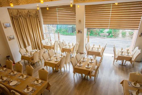 a restaurant with tables and chairs and a large window at 33 Soksoom Centre for Well-Being & Happinesss - Boutique Hotel in Thimphu