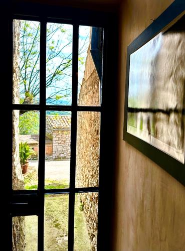 a window in a building looking out at a yard at Casa del Viaggiator Cortese in Toscolano