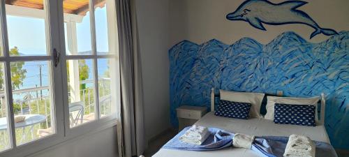 a bedroom with a dolphin mural on the wall at Amaranthos Skiathos View in Megali Ammos