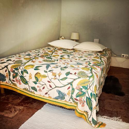 a bedroom with a bed with a floral comforter at B&B Vigne Vierge in Aigne