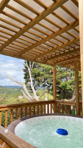 a wooden deck with a swimming pool with a wooden roof at Hermoso chalet en marinilla in Marinilla