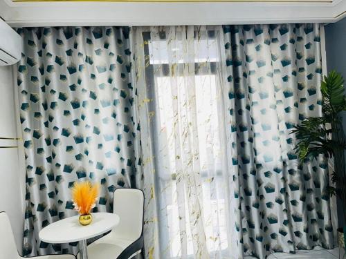 a room with a table and a window with curtains at GodIsGood Residency in Yaoundé
