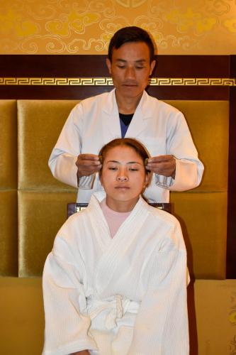 a man cutting a womans hair in a barber shop at 33 Soksoom Centre for Well-Being & Happinesss - Boutique Hotel in Thimphu