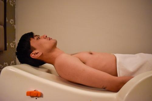 a naked man laying in a bath tub at 33 Soksoom Centre for Well-Being & Happinesss - Boutique Hotel in Thimphu