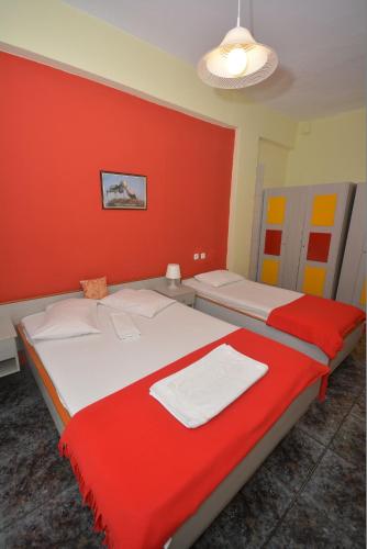 two beds in a room with red walls at Hotel Dias Apartment in Makrýgialos